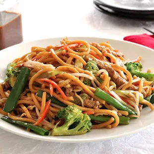 a plate of noodles with meat and vegetables