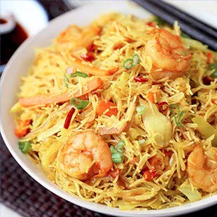 a bowl of noodles with shrimp and vegetables