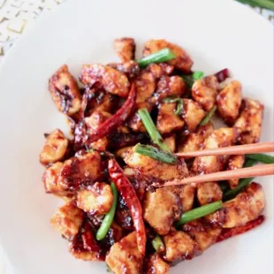 a plate of chinese food with chopsticks