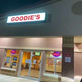 the front of a goodies store at night