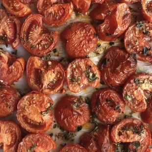 a close up of tomatoes on a baking sheet