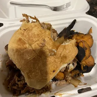 a pulled pork sandwich in a styrofoam container