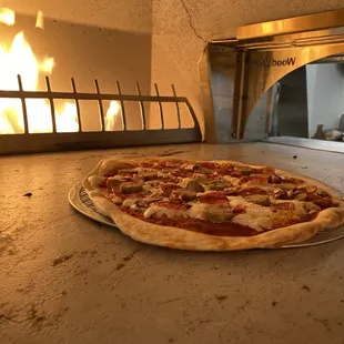 a pizza in a pizza oven