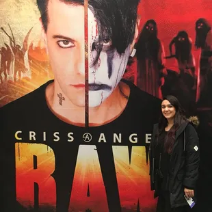 a woman standing in front of a movie poster