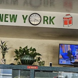 a clock on the wall above a television