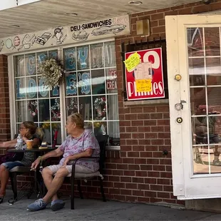 two women sitting outside a restaurant