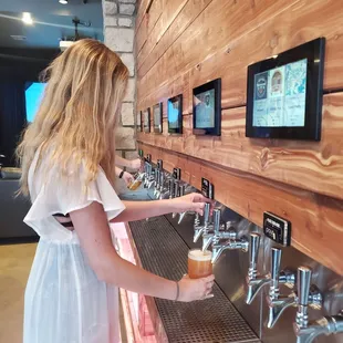 a woman filling a beer from a tap