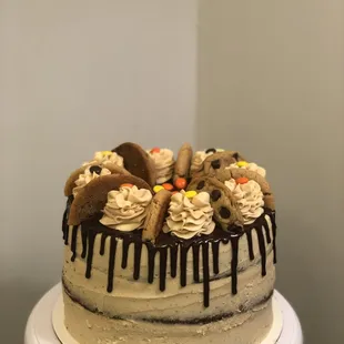 Reese&apos;s dreams cake! Fudge cake layers, peanut buttercream, ganache drip, peanut butter cookies from Moony&apos;s Sweets and Treats