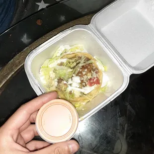 a person holding a container of food