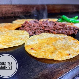 a variety of tacos on a grill