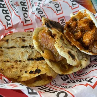 Grilled Gordita with chicharrón in green chili sauce and pork in red sauce.