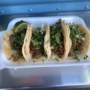 three tacos in a styrofoam container