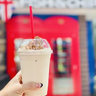 a hand holding a drink