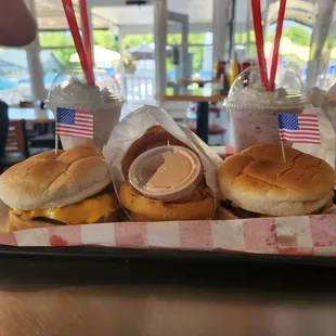 Two cheeseburgers, side of onion rings, blackberry shake (right), oreo shake(left)
