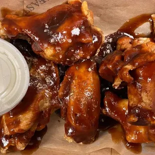 a plate of barbecued wings and a drink