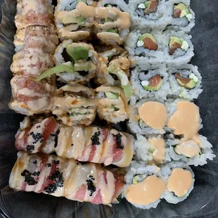 Top (left to right): Godzilla, crunchy spicy salmon, philly roll Bottom (left to right): two spicy trio rolls, spicy scallop roll