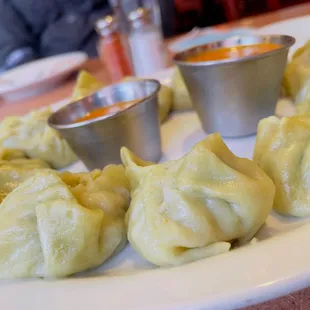 a plate of dumplings with dipping sauce