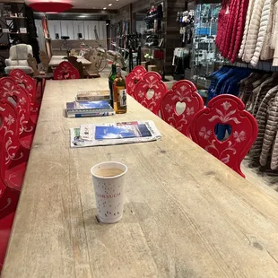 a wooden table and red chairs