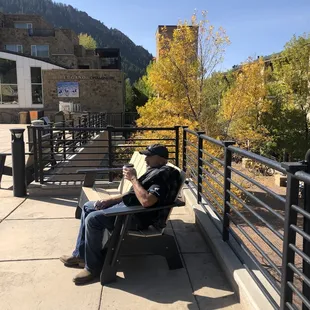a man sitting on a bench reading a book