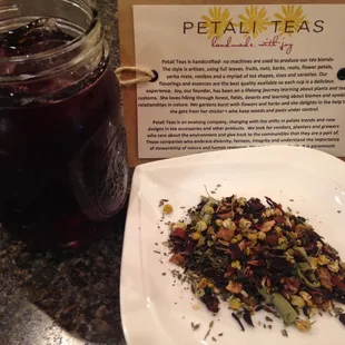 a jar of tea next to a plate of dried tea