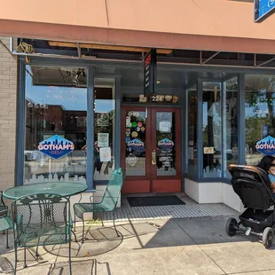 a man sitting in a stroller outside a deli