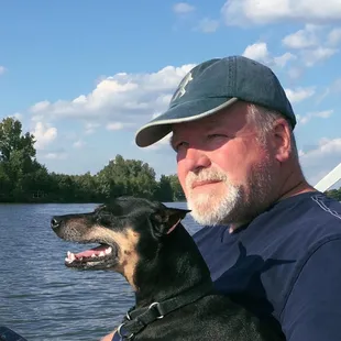 a man and his dog on a boat