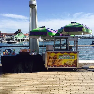 a hot dog cart with umbrellas