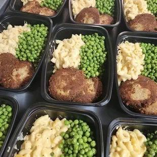 a tray of meat patties, macaroni and cheese and peas