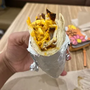 a hand holding a burrito