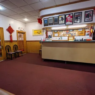 Inside. Facing the entrance/exit from the dining room, as well as the counter with the registers and phone.