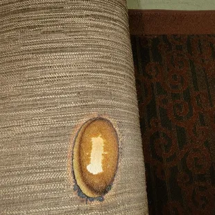 Burn hole on the couch arm.