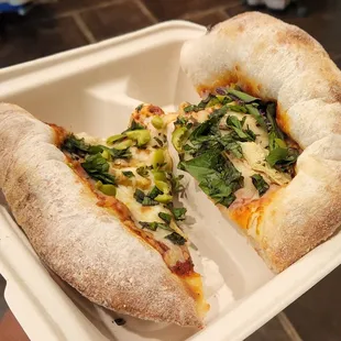 a half eaten pizza in a styrofoam container