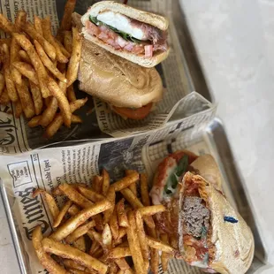 two trays of french fries and a sandwich