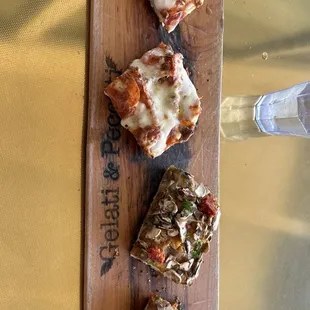 three slices of pizza on a cutting board