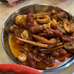 a bowl of seafood and corn on the cob