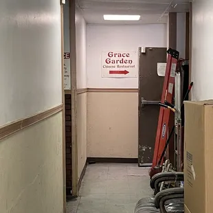 an empty hallway with chairs and a sign