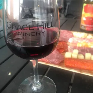 a glass of wine and a plate of meat