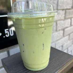 a green drink in a plastic cup