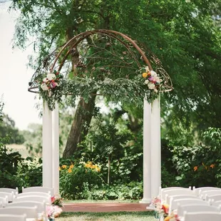 a wedding arch decorated with flowers and greenery