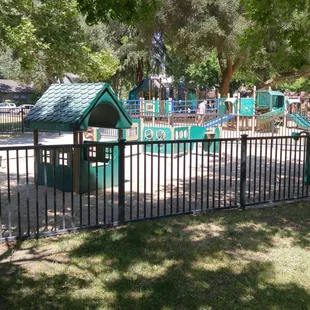 Toddler play area, semi fenced, in front of larger big kid playground.