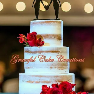 a couple holding hands on top of a wedding cake