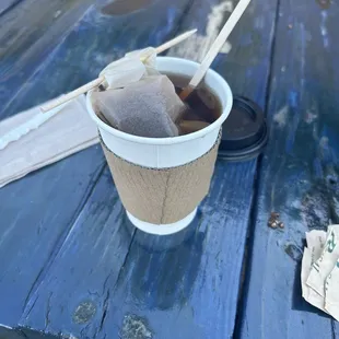 a cup of coffee on a picnic table