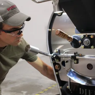 a man working on a coffee roaster