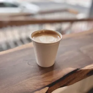 a cup of coffee on a wooden table