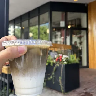 a hand holding a cup of coffee
