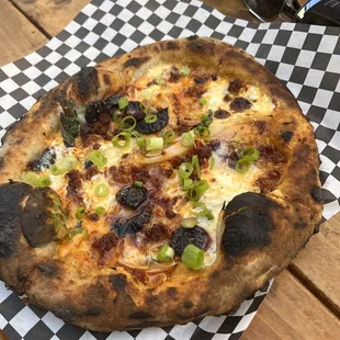 a pizza on a checkered napkin