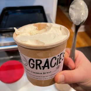 a hand holding a cup of ice cream