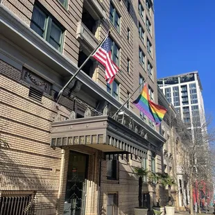 a rainbow flag flying in front of a hotel