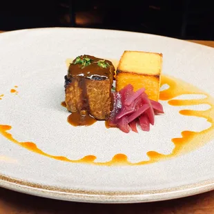 Brined and roasted pork shoulder, creamy polenta cake, pickled onions, natural jus