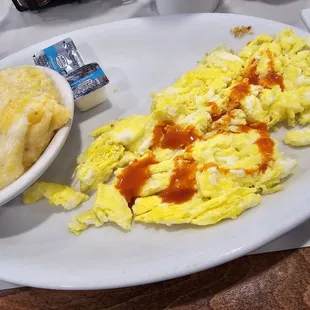 Scrambled eggs with hot sauce and cheese grits